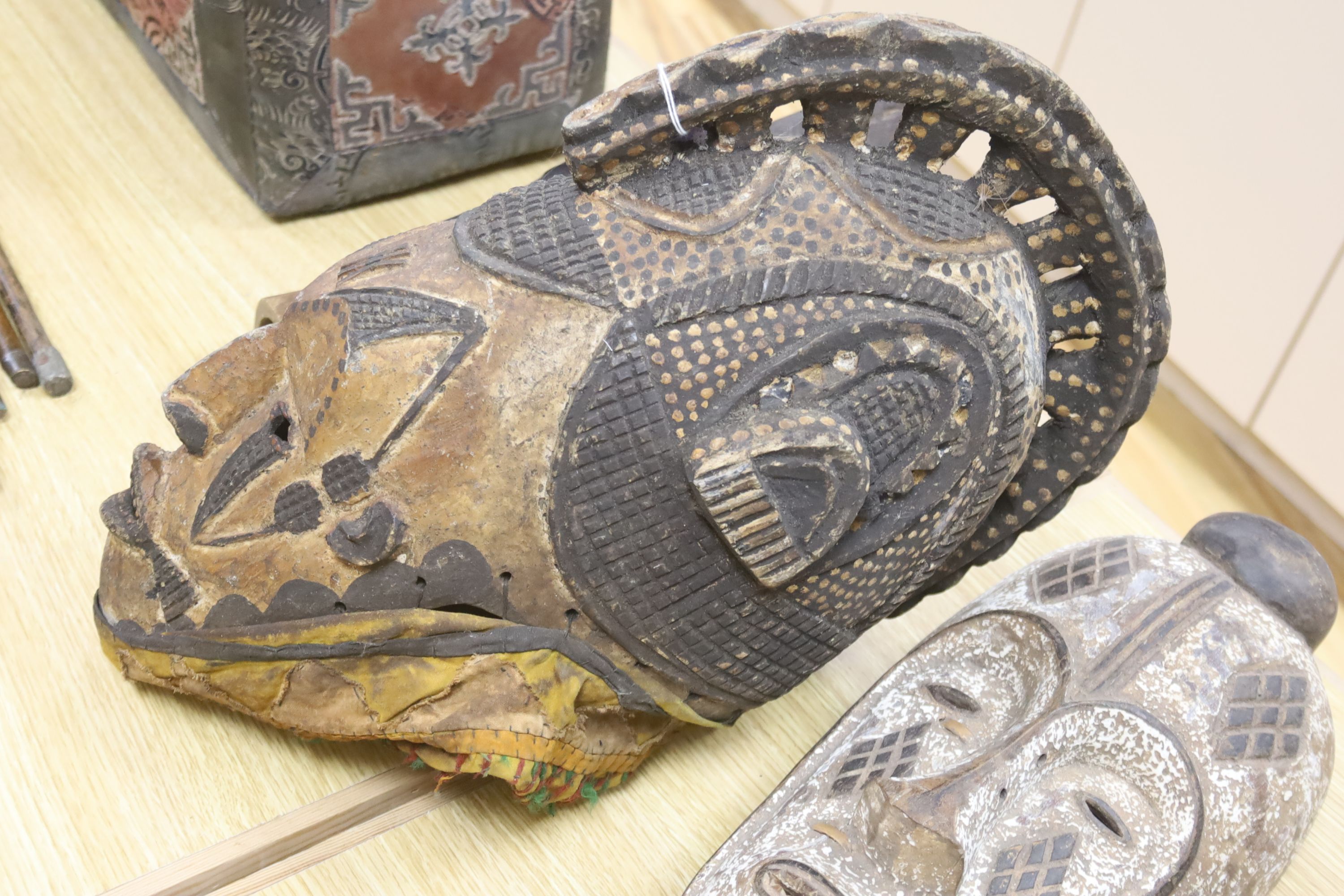 An African helmet mask, possibly Kaba, and two others